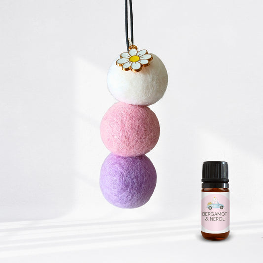Pastel-colored scented diffuser beads with a small bottle labeled 'Bergamot & Neroli' on a white background