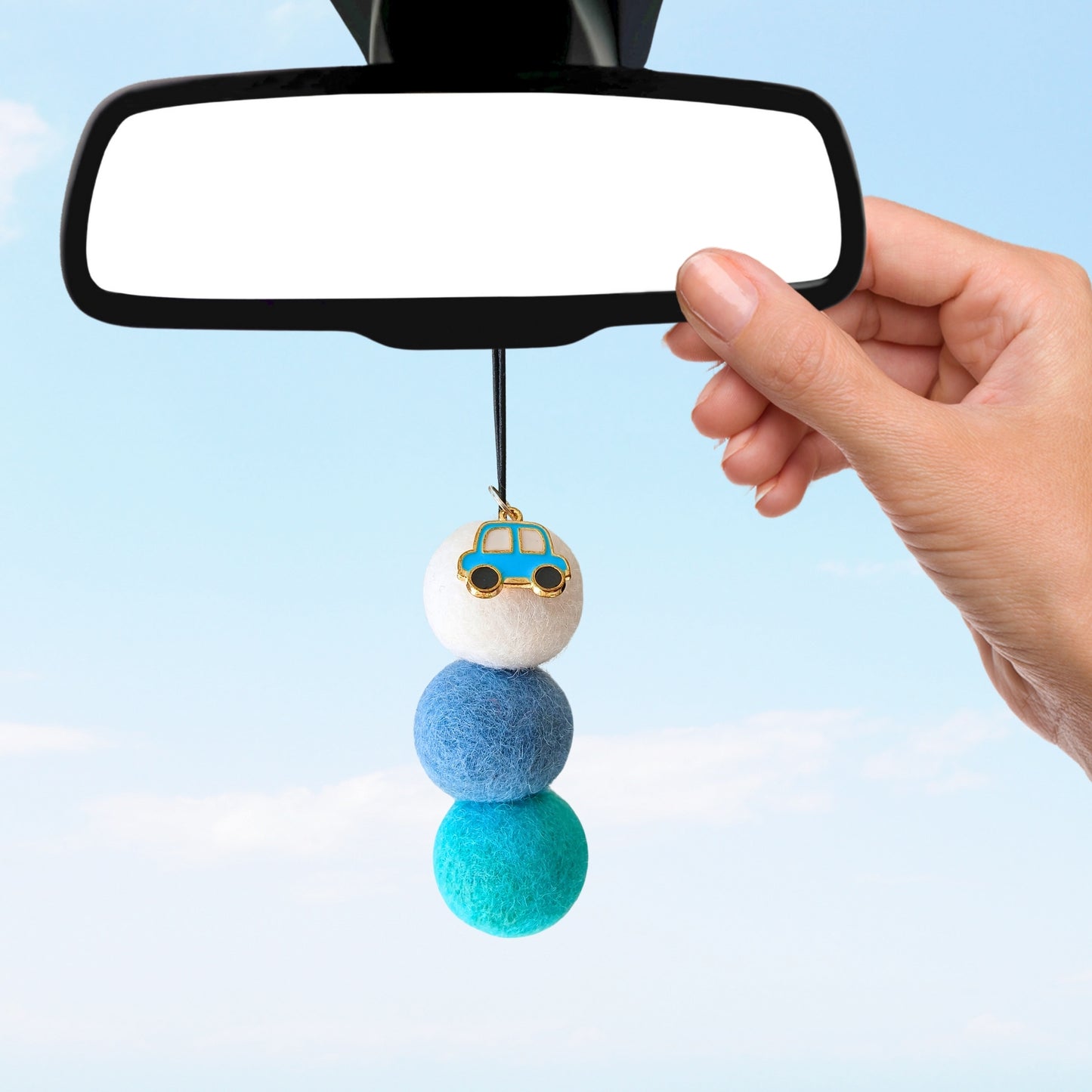 Car air freshener with colorful beads hanging from a car mirror against a light blue background