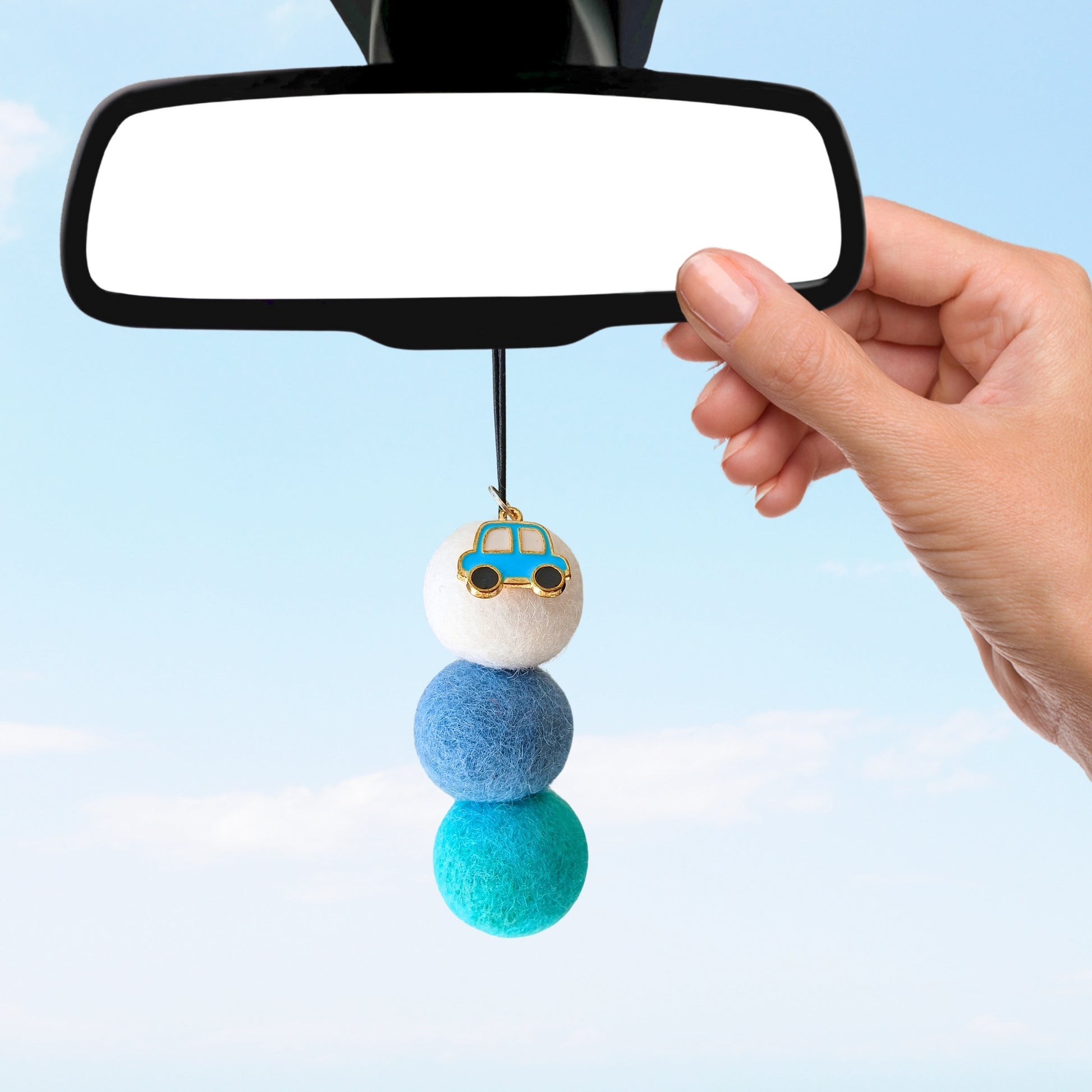 Car air freshener with colorful beads hanging from a car mirror against a light blue background