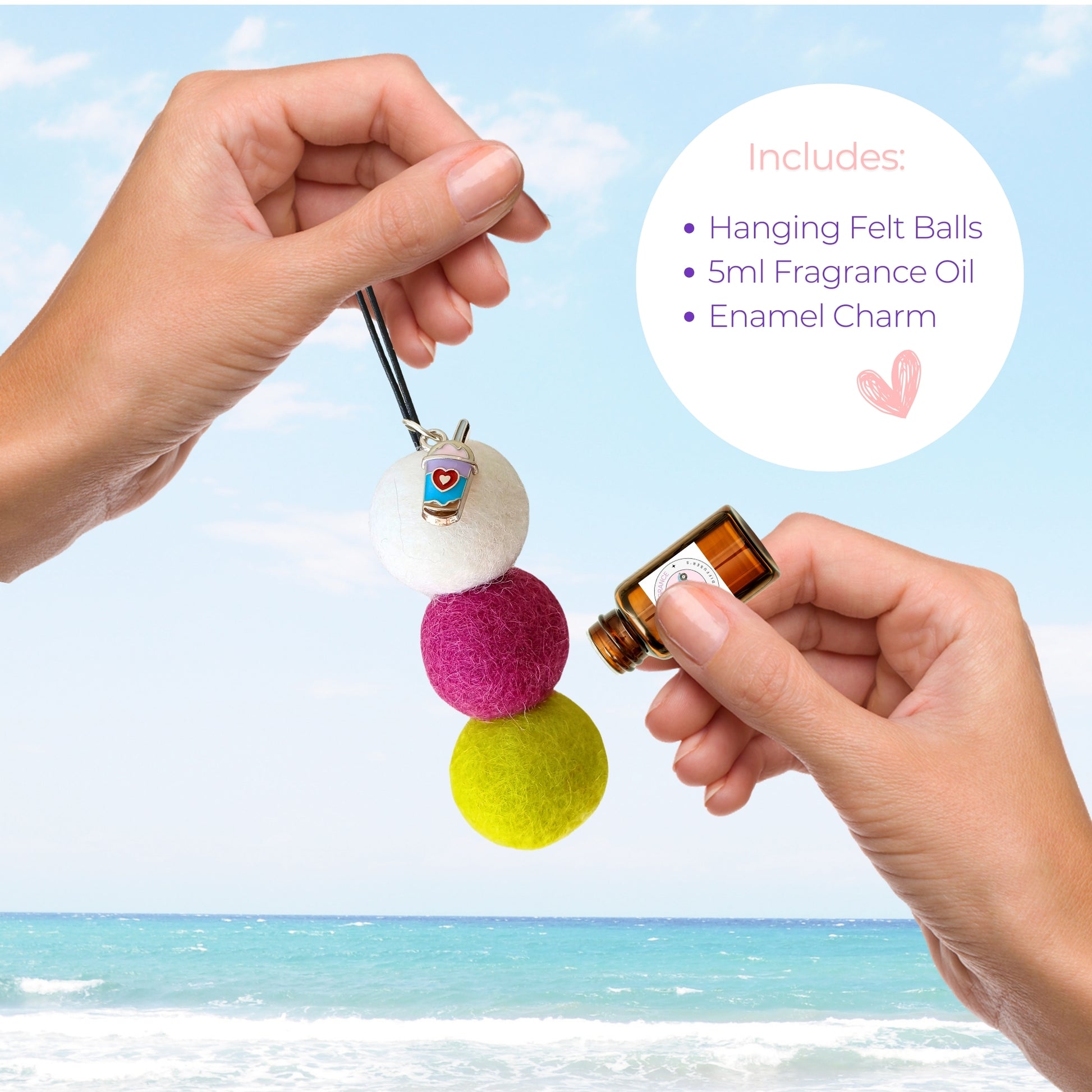 Colorful hanging felt ball with a small bottle of fragrance oil against a beach background