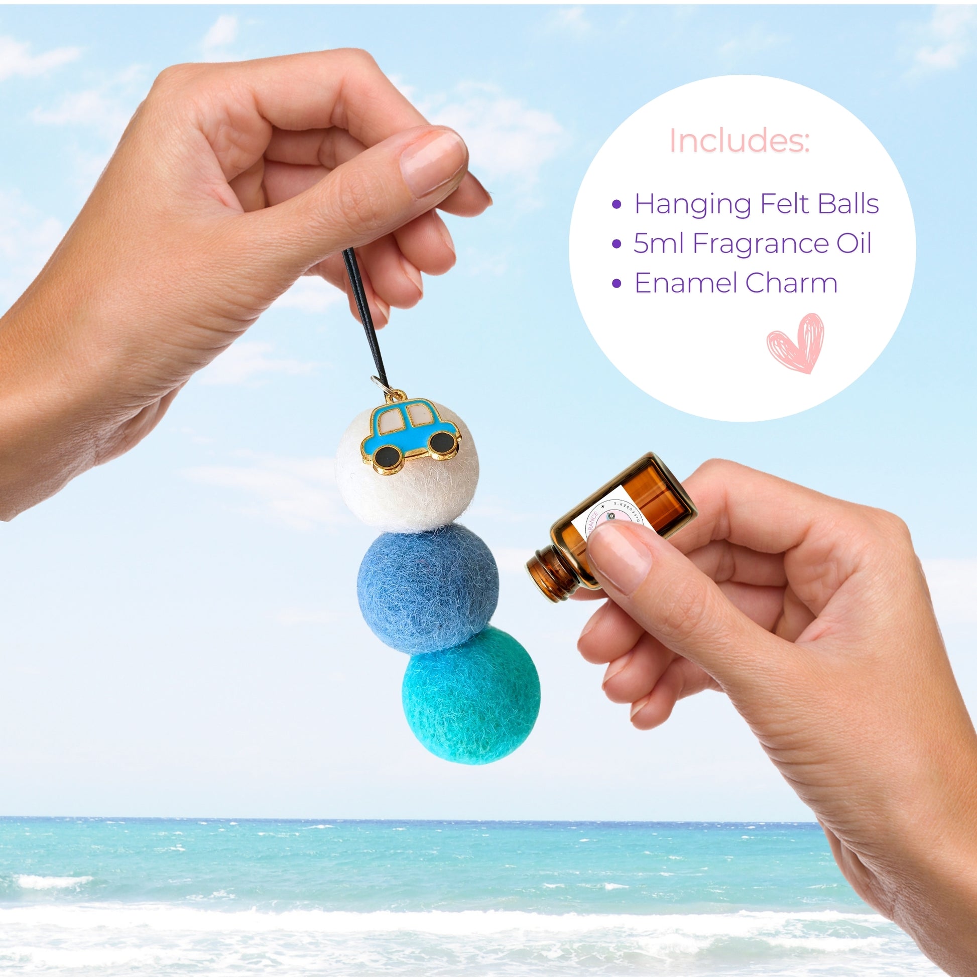 Hanging felt ball diffuser with fragrance oil and enamel charm against a beach background