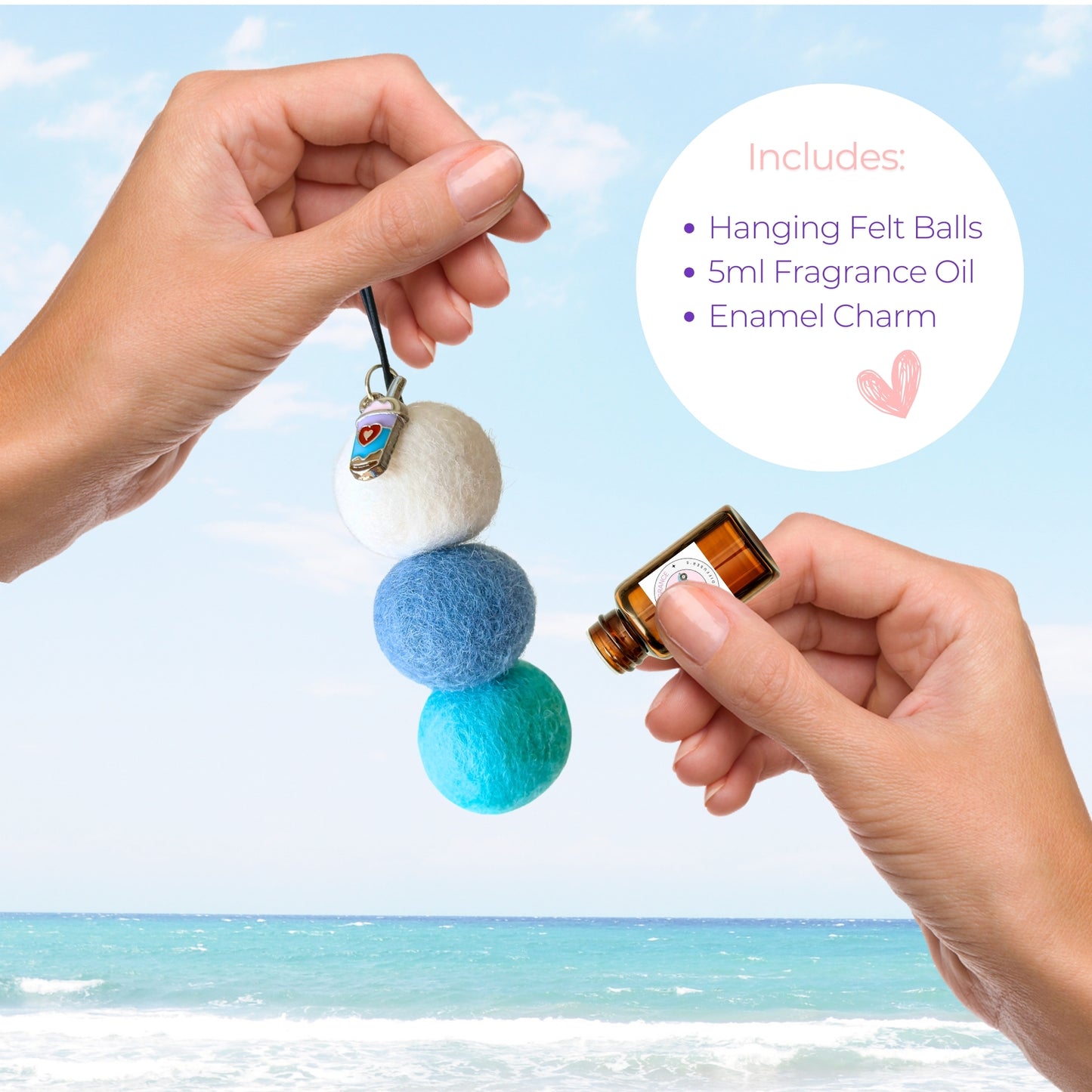 Hanging felt ball diffuser with fragrance oil and enamel charm against a beach background