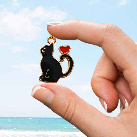 Show your feline love with this adorable black cat enamel charm featuring a red heart accent—purrfect for charm collectors